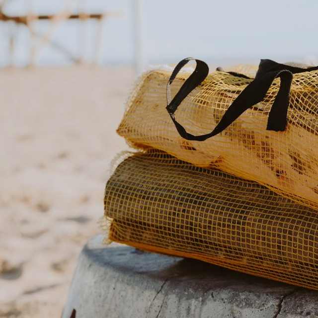 Sacs filet remplis de bûches de bois sec, prêts pour la livraison